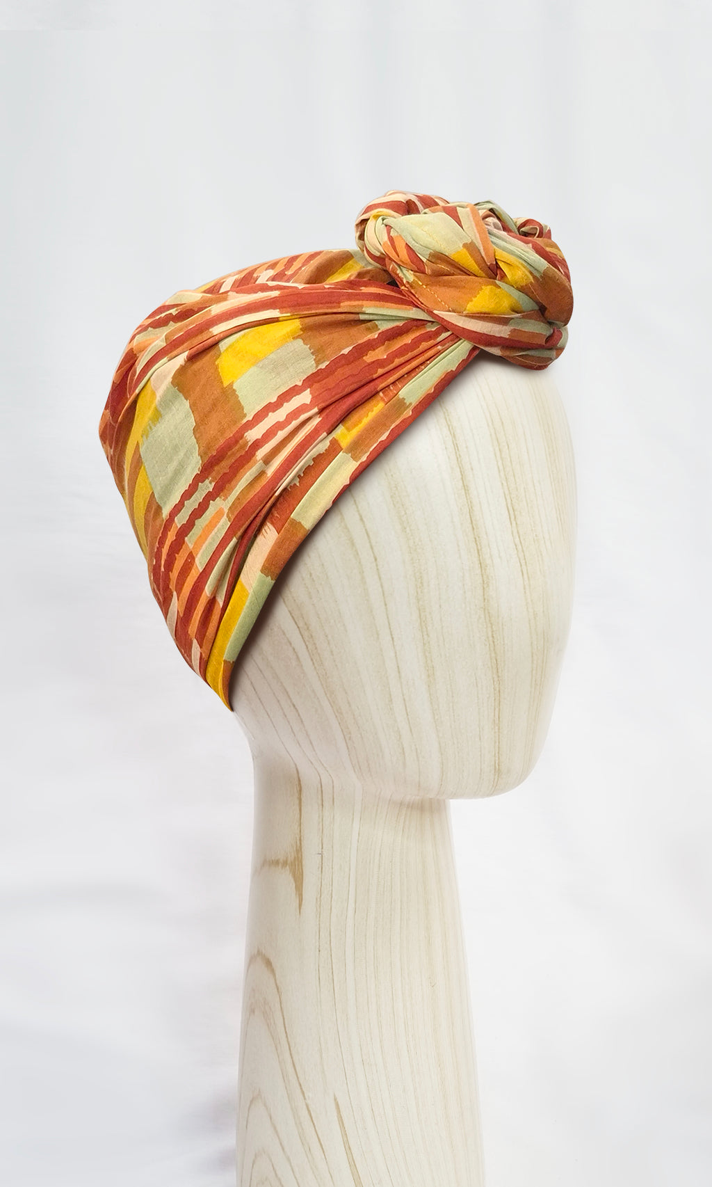 Side view of Celine Martine Josephine Head Wrap in Ember print, wrapped in a sculptural turban style with painterly stripes and concealed wire