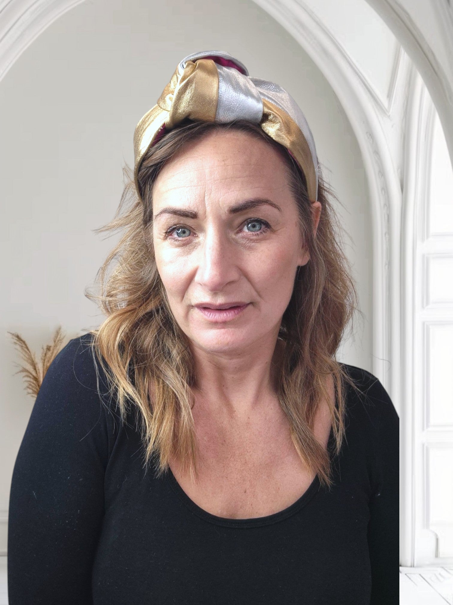 Model wearing gold and silver leather Simone Headband by Celine Martine, crafted for comfort with cotton lining and sculptural top knot