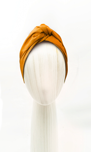 eline Martine Josephine Head Wrap styled in a high twisted knot on a woman with white blouse, demonstrating its secure, no-slip fit