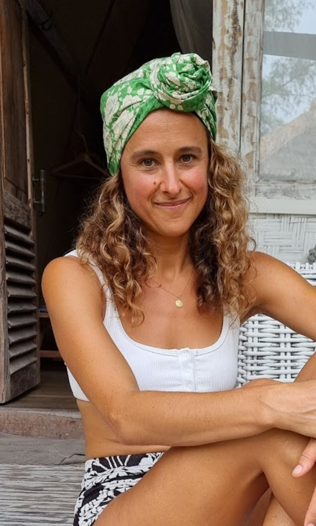 A Celine Martine wired head wrap displayed on Carmela who is sitting on veranda in Bali
