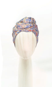 The Celine Martine wired head wrap in Elanora Blue displayed on a mannequin head styled in one of several hair scarf options
